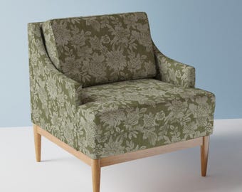 May include: A green armchair with a floral pattern upholstery and wooden legs.