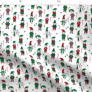 May include: White fabric with a repeating pattern of green and red elves wearing pointy hats and holding candy canes. The elves are surrounded by small green shamrocks.