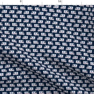 May include: A navy blue fabric with a repeating pattern of white mail trucks. The trucks have red accents and a white stripe.