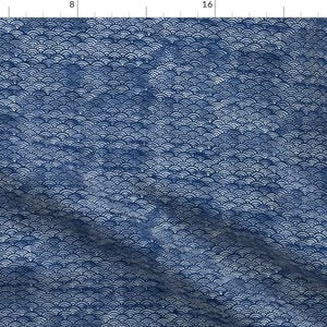 May include: A blue fabric with a white wave pattern. The fabric has a subtle texture and a slightly wrinkled appearance.