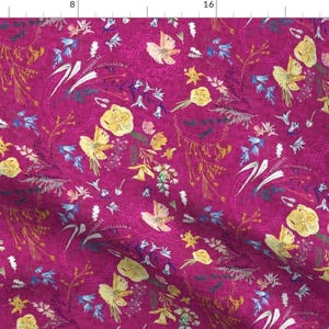 May include: A pink fabric with a floral pattern featuring yellow flowers, blue flowers, and butterflies. The background is a deep pink colour.