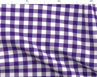 Op de afbeelding: Een stof met een klassiek vichy-patroon in paars en wit. Het ontwerp bestaat uit een herhalend raster van vierkanten, waardoor een geruit effect ontstaat. De stof is geschikt voor kleding, woondecoratie of knutselwerk.