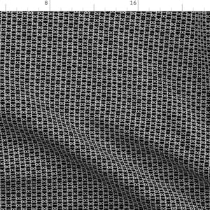 May include: A black and white fabric with a repeating pattern of small circles. The circles are arranged in a grid pattern.