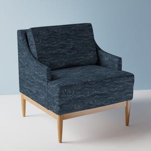 May include: A blue armchair with a wave pattern upholstery and wooden legs.