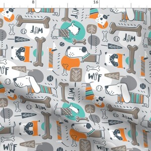 May include: A seamless pattern featuring a light grey background with a repeating design of cartoon dogs wearing jumpers, bones, and the word "WOF". The dogs are in shades of brown, white, and black, and the jumpers are in shades of blue, orange, and teal.