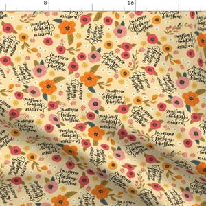 May include: A yellow floral fabric with a repeating pattern of pink, orange, and yellow flowers. The fabric has the text "I'm a ray of fucking sunshine" repeated throughout the pattern.