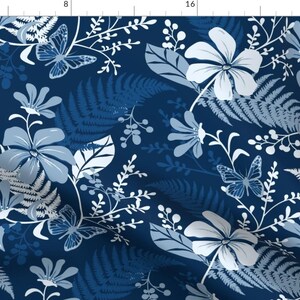 Op de afbeelding: Een naadloos patroon met witte en blauwe bloemenontwerpen op een donkerblauwe achtergrond. Het patroon bevat vlinders, varens en verschillende bloemen.
