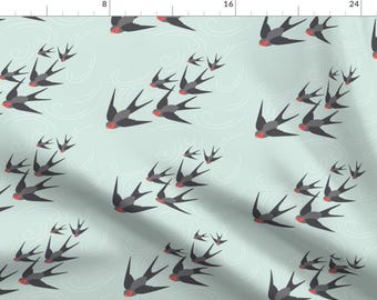 May include: A seamless pattern featuring a repeating design of stylized black swallows with red accents flying against a light blue background.