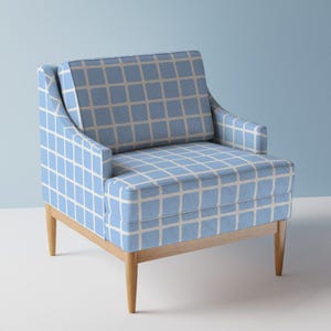 May include: A light blue armchair with a white grid pattern upholstery and wooden legs.