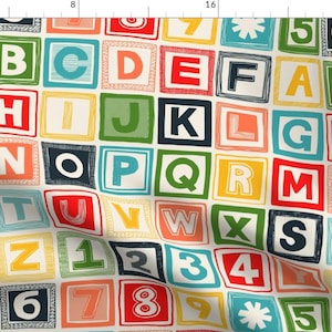 Può includere: Un motivo di tessuto colorato con un design ripetitivo di lettere dell'alfabeto e numeri in stile blocco. Le lettere e i numeri sono di vari colori, tra cui rosso, blu, verde, giallo e arancione. Lo sfondo è bianco.
