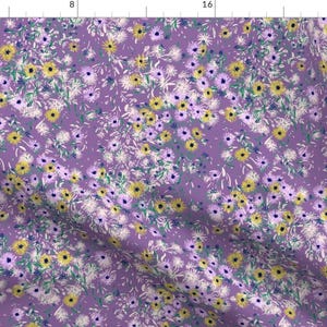 May include: A purple fabric with a floral pattern featuring yellow, white, and purple flowers. The flowers are scattered randomly across the fabric.
