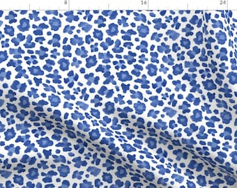 May include: A white fabric with a blue leopard print pattern. The print is a watercolor style with shades of blue.