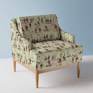 May include: An upholstered armchair with light green fabric featuring a repeating pattern of red ladybugs, small flowers, and green foliage. The chair has a square backrest, a cushioned seat, and four tapered wooden legs in a light brown finish.