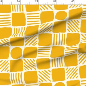 Puede incluir: Un patrón sin costuras que presenta un diseño geométrico repetitivo de cuadrados y círculos en color amarillo mostaza sobre un fondo blanco.
