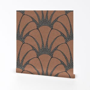 May include: Wallpaper roll featuring a repeating Art Deco fan design. The pattern has a terracotta background with black outlines and small gray dots. The roll is partially unrolled, showing the design.