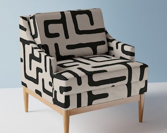 May include: A beige armchair with wooden legs and a black and white geometric pattern.