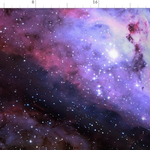 May include: A fabric print featuring a deep space nebula with vibrant purple, magenta, and blue gaseous clouds scattered with numerous bright white stars. A ruler along the top and left edges shows measurements in inches.