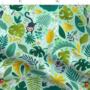 May include: A seamless pattern featuring a variety of jungle animals and plants on a light blue background. The pattern includes monkeys, snakes, frogs, hummingbirds, and leaves in shades of green, yellow, and brown.