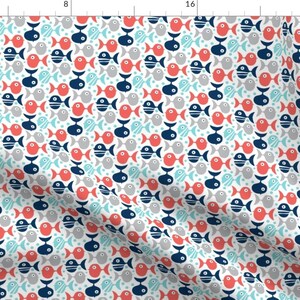 May include: A white fabric with a repeating pattern of red, blue, and gray fish. The fish are all different shapes and sizes, and some have stripes or dots. The background is white.
