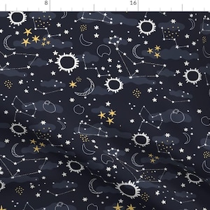 May include: A dark blue fabric with a white and gold celestial pattern. The pattern includes stars, moons, suns, and constellations.