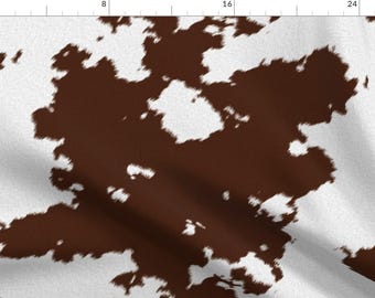 Könnte beinhalten: Braunes und weißes Kuhfellmuster mit einer flauschigen Textur.