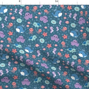 May include: A teal fabric featuring a repeating pattern of cartoon sea creatures. Whales, octopuses, jellyfish, seahorses, turtles, and starfish are depicted in shades of blue, purple, orange, and green. The design is whimsical and suitable for children's items.