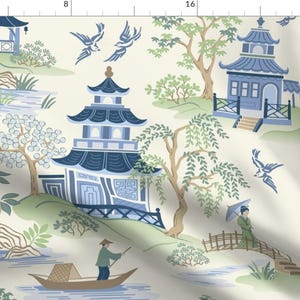 Può includere: Un motivo chinoiserie blu e bianco con pagode, ponti e uccelli. Lo sfondo è di colore crema chiaro.