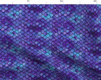 May include: A fabric featuring a repeating pattern of overlapping diamond-shaped scales in shades of deep purple, violet, and bright cyan blue. The surface has a textured appearance with light and dark gradients creating a sense of depth.