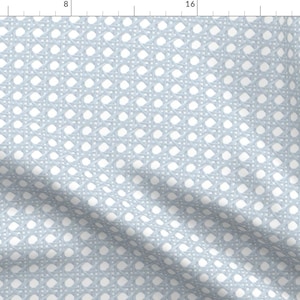 May include: A light blue fabric with a white woven pattern of small circles and lines. The fabric has a subtle texture and a slightly wrinkled appearance.