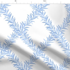 May include: A textile fabric featuring a repeating diamond lattice pattern composed of light blue leafy vines on a solid white background. The design is displayed against a ruler showing measurements in inches along the top and left edges.