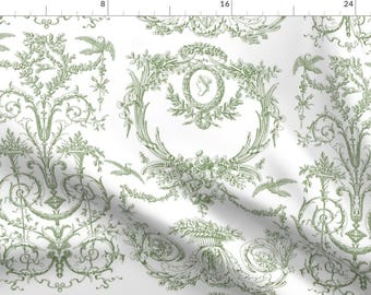 May include: A white fabric with a repeating pattern of green stylized floral and bird motifs. The pattern is reminiscent of a traditional French toile design.