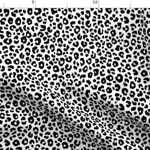 May include: Black and white leopard print fabric with a repeating pattern of black spots on a white background.