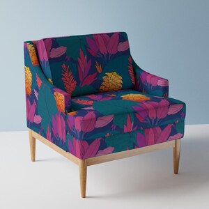 Op de afbeelding: Een turquoise fauteuil met een bloemenpatroon met roze, oranje en gele bloemen. De stoel heeft houten poten en een hoge rugleuning.