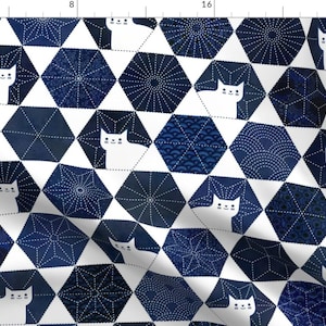 May include: White cats peek out from behind blue and white geometric patterned hexagons. The pattern is reminiscent of Japanese Sashiko stitching.