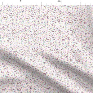 Peut inclure: Tissu crème avec un motif répétitif de petites formes colorées en forme de feuilles. Les formes sont dans des tons de violet, bleu, vert et jaune. Le tissu est plié, créant des ombres.