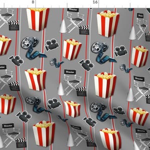 May include: A gray and red fabric with a repeating pattern of popcorn buckets, film reels, movie cameras, and director's chairs. The pattern is perfect for a movie-themed project.