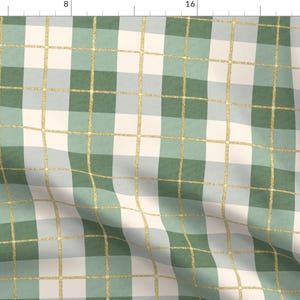 May include: A green and white plaid fabric with gold glitter accents. The fabric is folded and has a soft, textured feel.