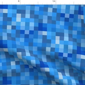 May include: A blue and white pixelated pattern with a diagonal design. The pattern is made up of small squares of different shades of blue.