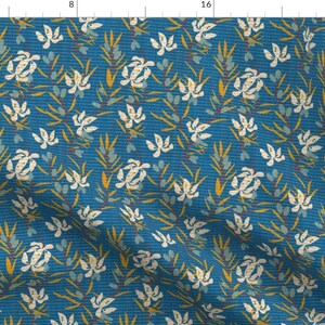 May include: A blue fabric with a white floral pattern. The flowers are stylized and have a yellow center. The fabric has a subtle texture.