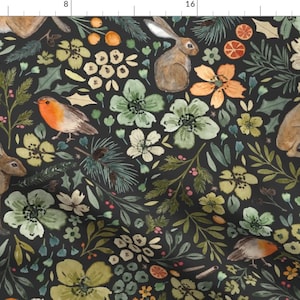 Puede incluir: Un estampado de tela con ilustraciones de acuarela de conejos, pájaros, flores y follaje en tonos verdes, naranjas y blancos sobre un fondo negro. El diseño tiene un tema caprichoso inspirado en la naturaleza.