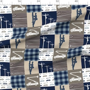 May include: A blue and brown patchwork fabric with a repeating pattern of a lineman climbing a utility pole, a bucket truck, and power lines. The fabric is perfect for quilting, crafts, and home decor.