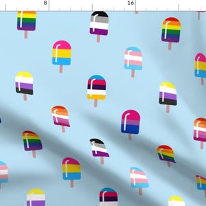 May include: Light blue fabric with a repeating pattern of colorful popsicle illustrations. Each popsicle features a different design, including rainbow stripes and various pride flag colors. The popsicles are on wooden sticks.