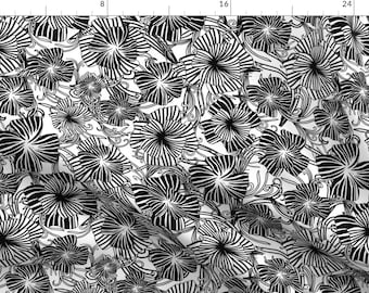 Op de afbeelding: Zwart-wit bloemenpatroon met gestileerde bloemen en kronkelende ranken. Het patroon is naadloos en herhaalt zich.