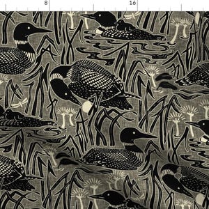 May include: Black and white fabric featuring a repeating pattern of loon birds swimming in a pond with reeds. The loon birds are stylised and have a geometric design.