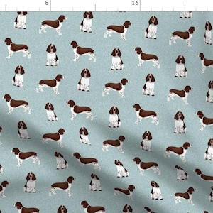 Könnte beinhalten: Ein nahtloses Muster mit einem sich wiederholenden Design von braunen und weißen English Springer Spaniel Hunden auf hellblauem Hintergrund.