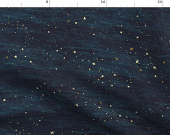 May include: Dark blue fabric with a textured appearance, scattered with numerous gold stars of varying sizes. The stars create a celestial pattern, reminiscent of a night sky. The fabric has a subtle, wavy texture.