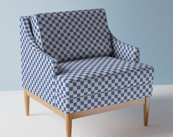 May include: A blue and white checkered armchair with wooden legs. The chair has a high back and a wide seat.