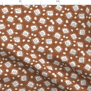 May include: A brown fabric with a repeating pattern of white snowmen with black eyes and mouths. The background is a brown color with small white dots.