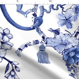 May include: Blue and white floral pattern fabric with a repeating design of flowers, vines, and tassels. The fabric has a white background and a blue floral pattern.