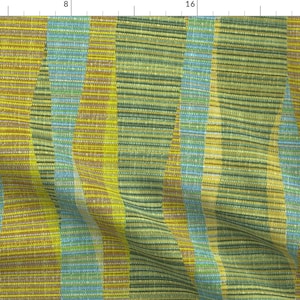 May include: A fabric with a striped pattern in shades of green, yellow, and blue. The fabric is woven with a subtle texture and has a slight sheen.